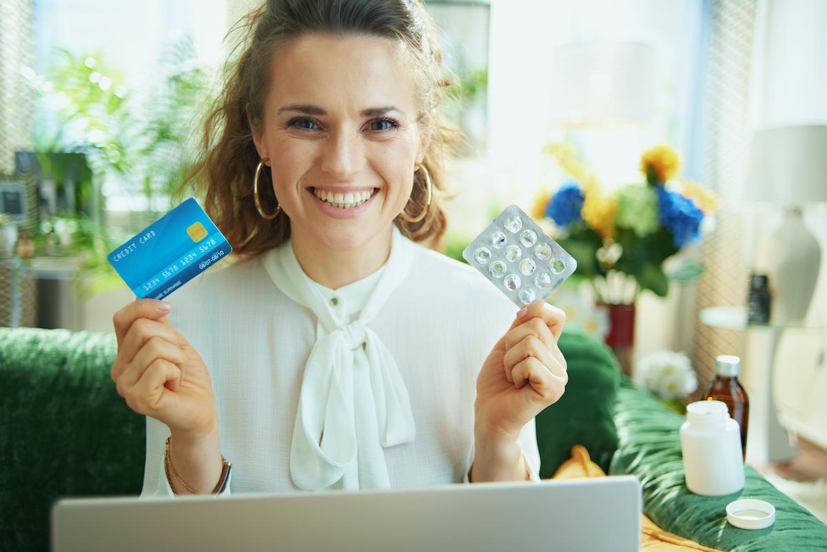 Happy smiling young woman at home ordering her prescription drugs online