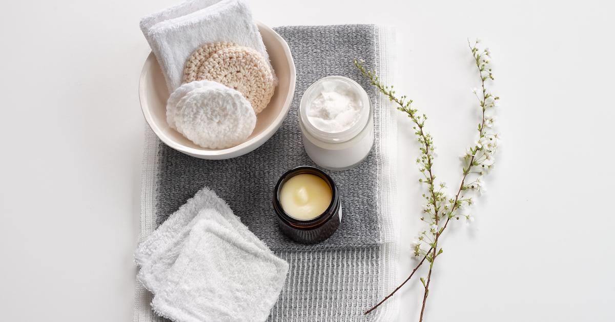 Reusable cotton rounds, candles, and lotion on a table