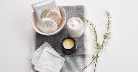 Reusable cotton rounds, candles, and lotion on a table