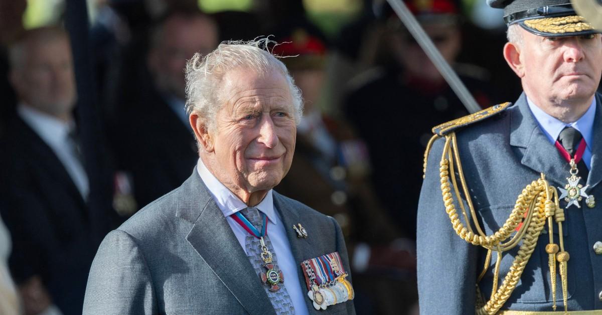 King Charles stands outside with his guards