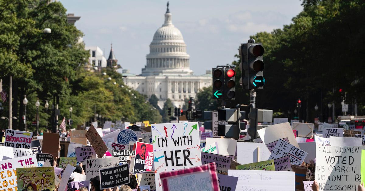 Feminist signs during the Women's March, with the U.S. Capitol Building in the background