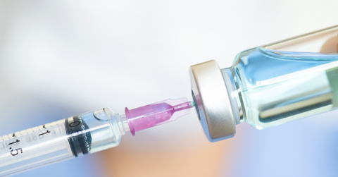 A small syringe is being used to withdraw medication from a vile