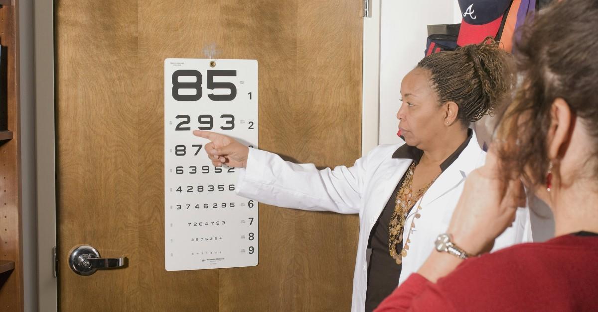 An eye doctor administers an eye exam to a woman