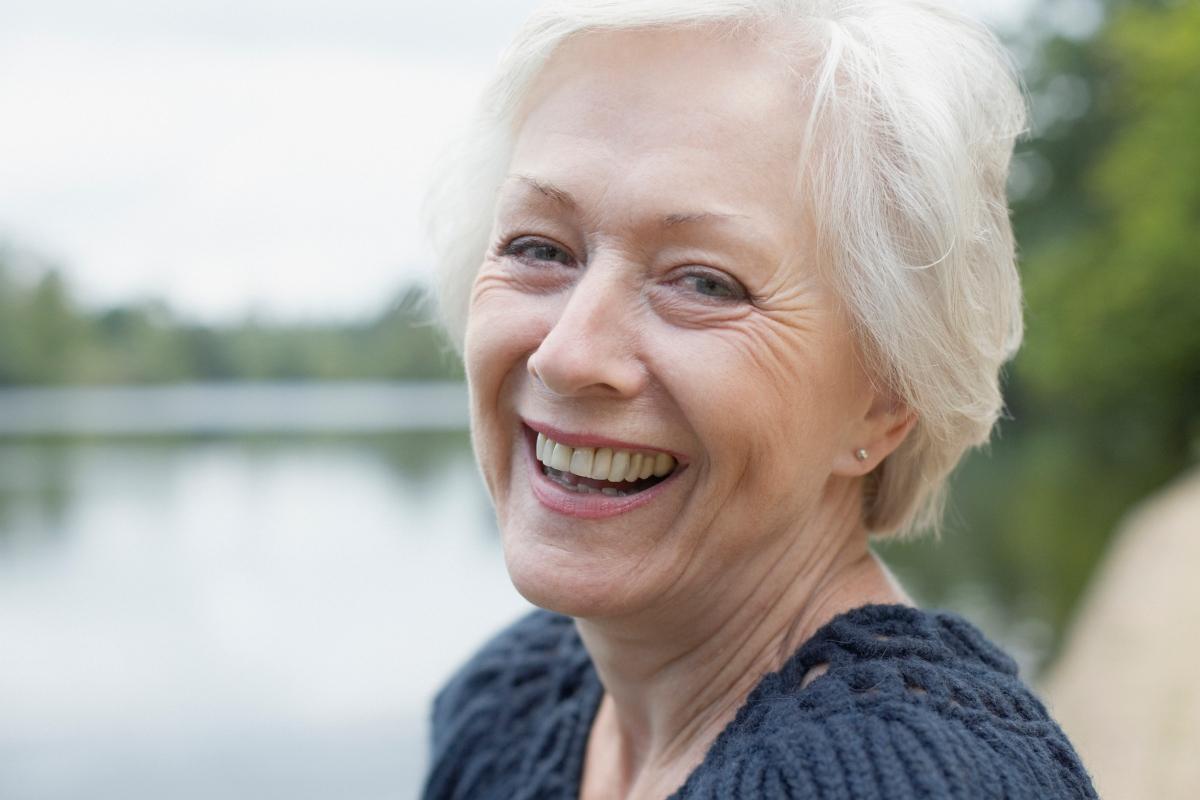 smiling senior woman by the water