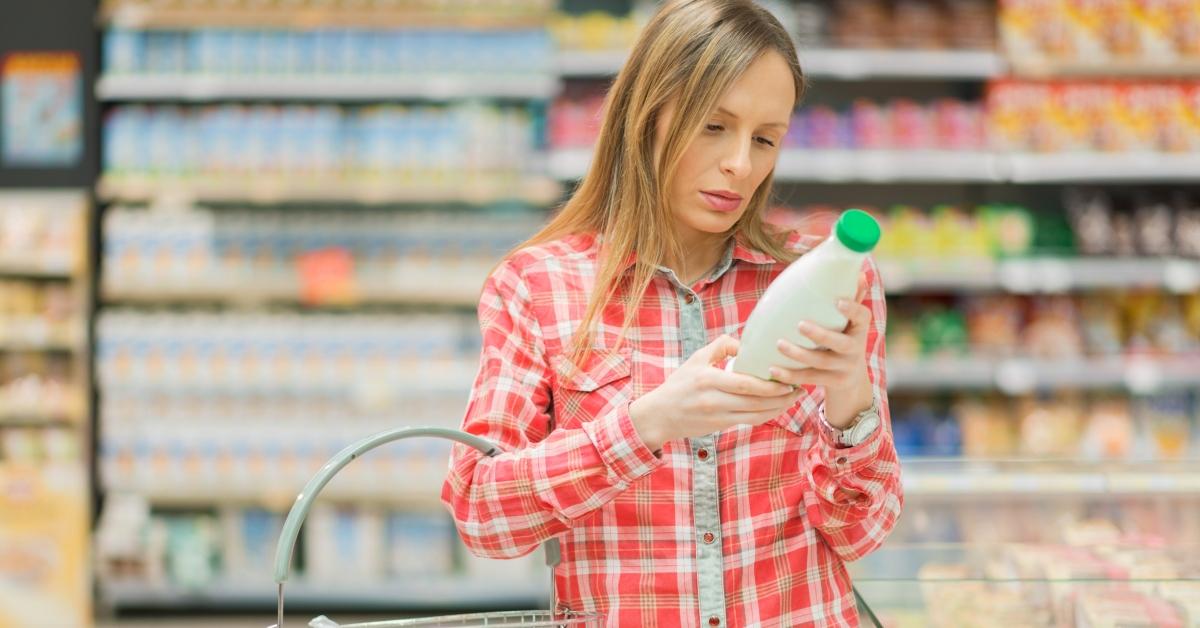 Woman checks expiration date on a bottle of milk.