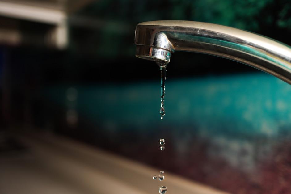 A close-up of water dripping from a faucet. 