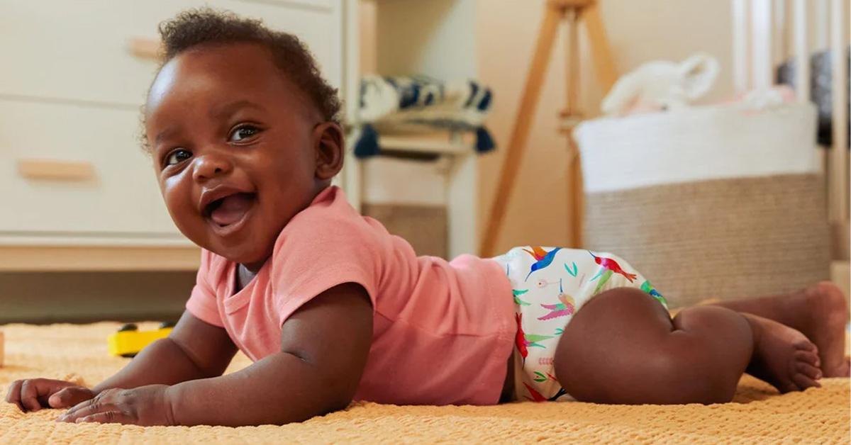 smiling baby wearing a cloth diaper and a t-shirt