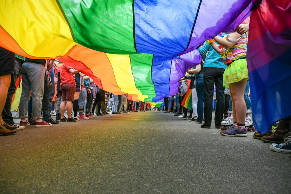 A giant rainbow flag and people's feet.