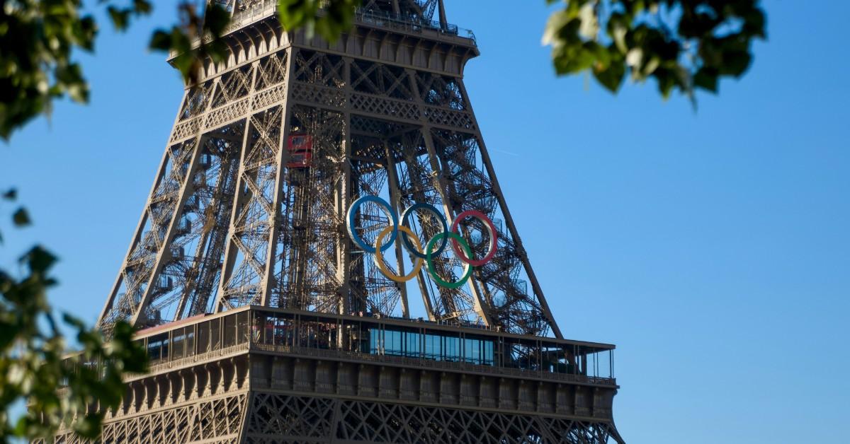 The colorful Olympic rings hang on the front of the Eiffel Tower