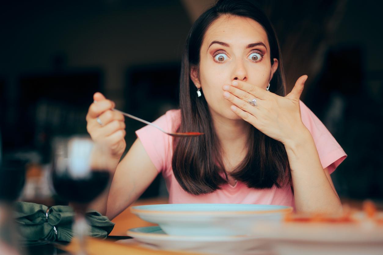 A woman becomes nauseated while consuming food in a restaurant.