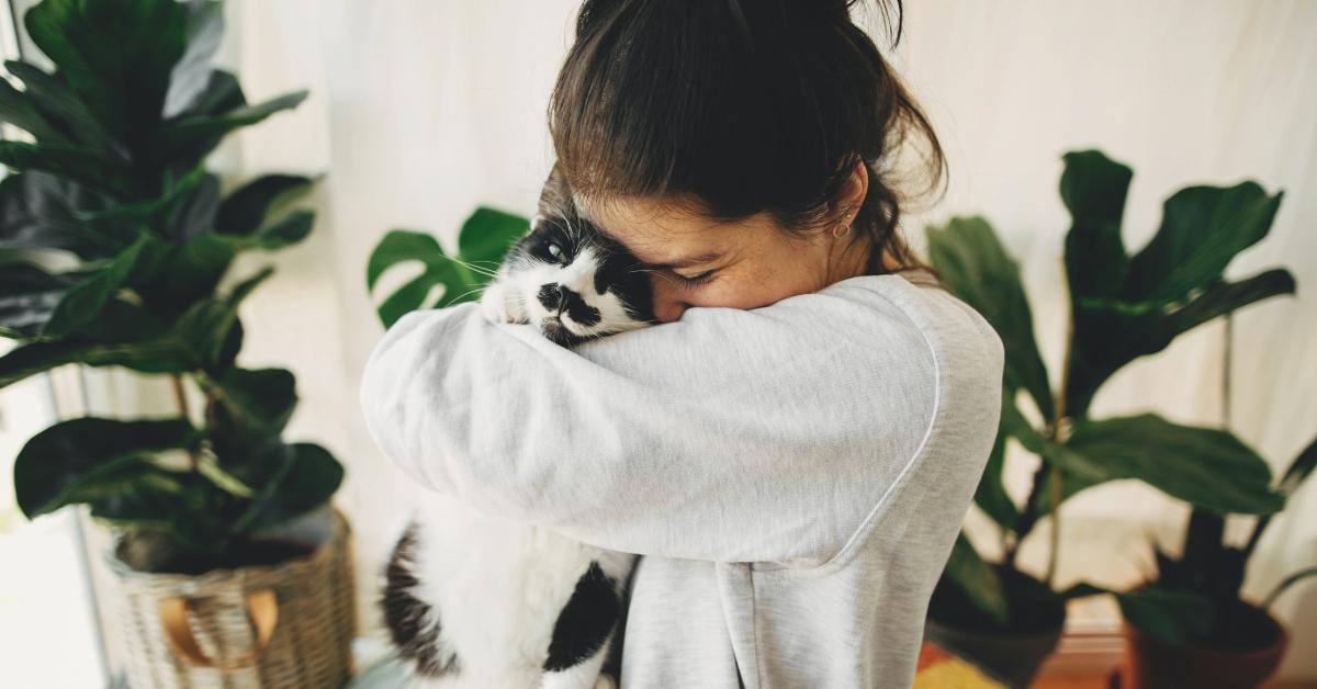 A girl hugging her cat. 