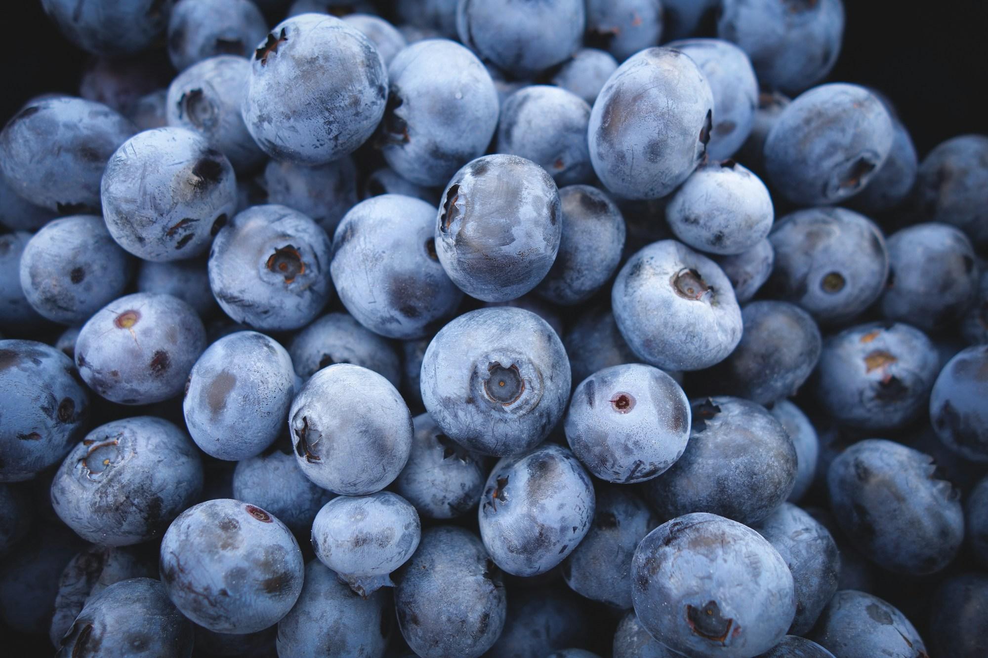 Bunches of blueberries are pictured stacked atop one another.