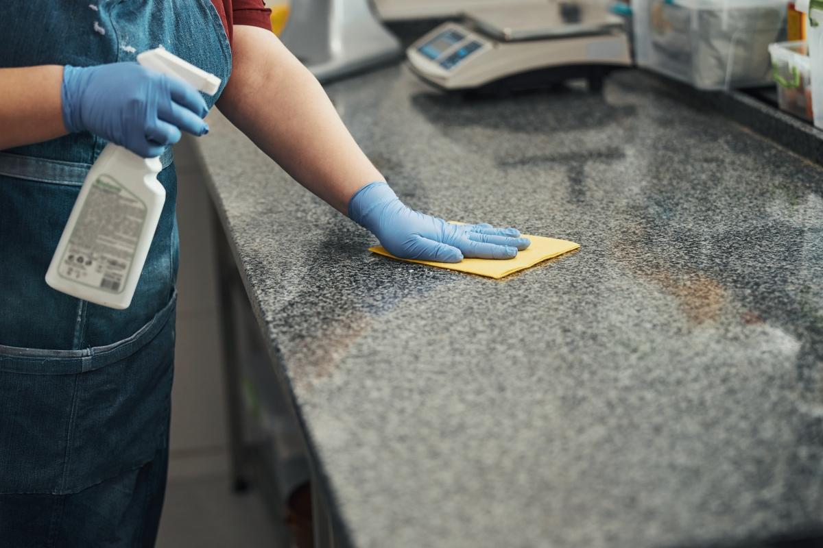 Person disinfecting kitchen countertops