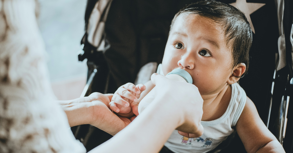 A mother feeds her baby using a bottle