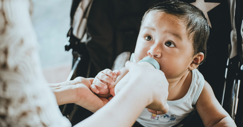 A mother feeds her baby using a bottle