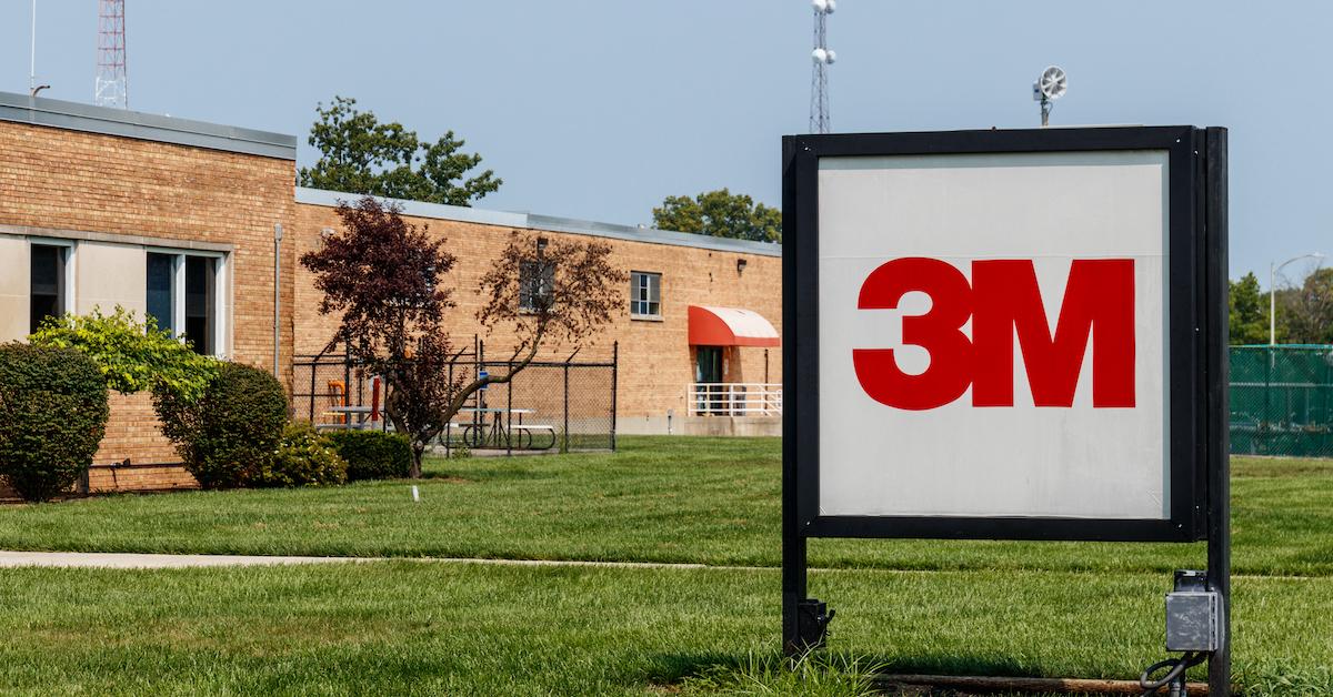 A 3M sign on a lawn in front of a building