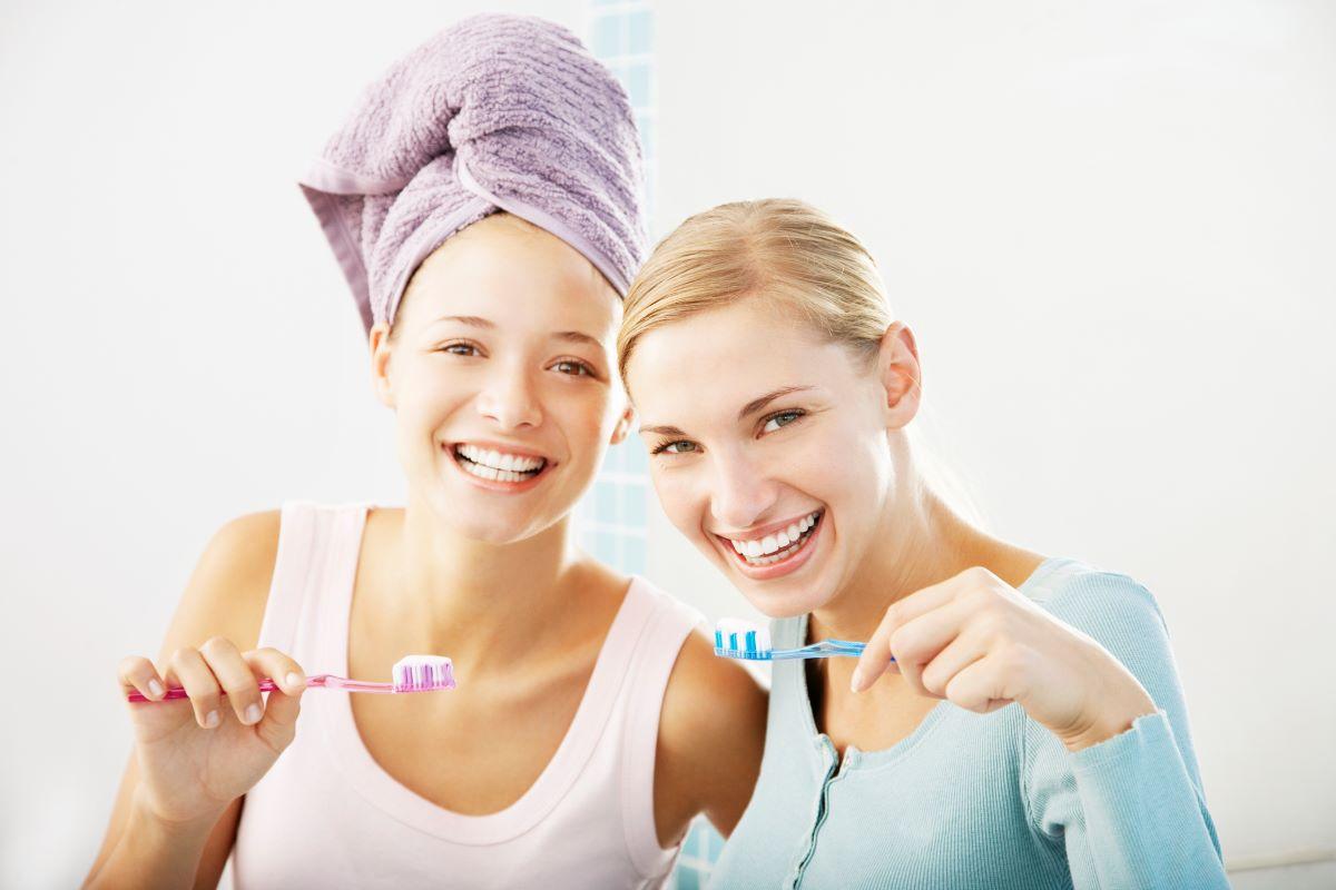 Women practicing good oral hygiene by brushing their teeth