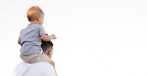 A man carries a young child on his shoulders