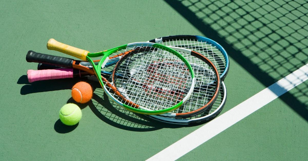 Tennis racquets with colorful handles on the court 