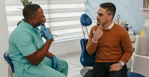A man visiting the dentist about tooth pain.