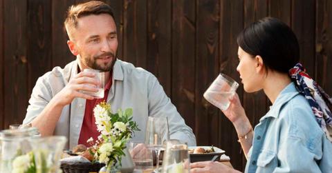 Man and woman drinking water while having a meal on a table (Representative Image Source: Freepik)