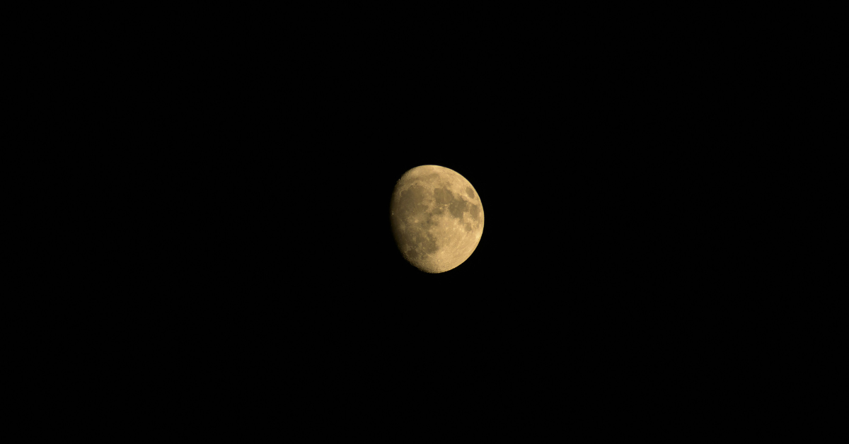 A partially eclipsed full harvest moon in the night sky