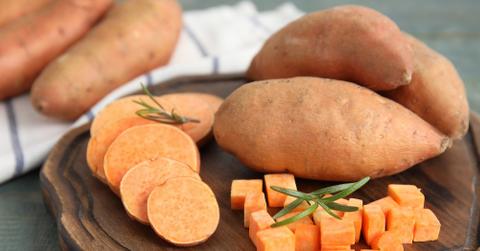 Sweet potatoes sliced and cubed on a wooden tray.
