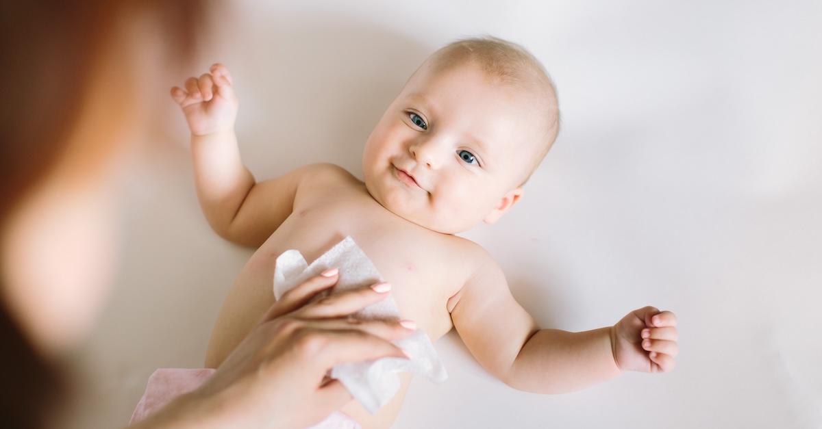 Baby on changing table with stomach being wiped