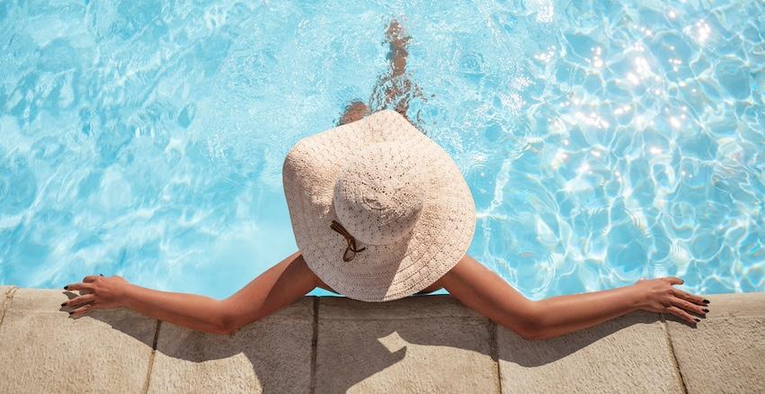 A woman wearing a sun hat in a pool. 