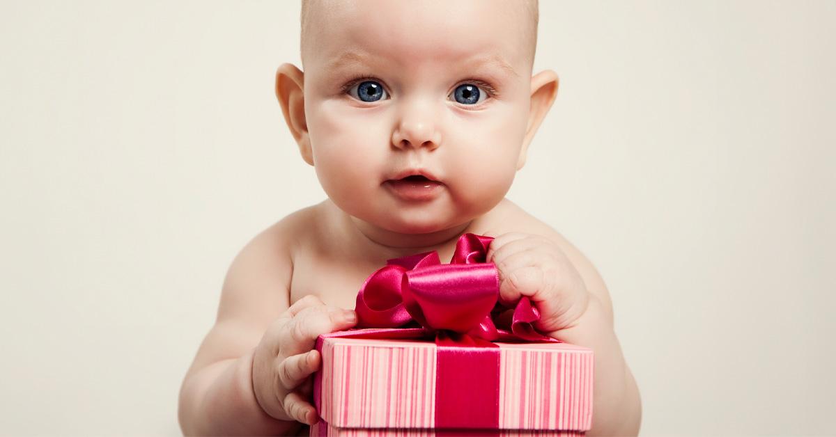 baby holding a gift box with a pink bow