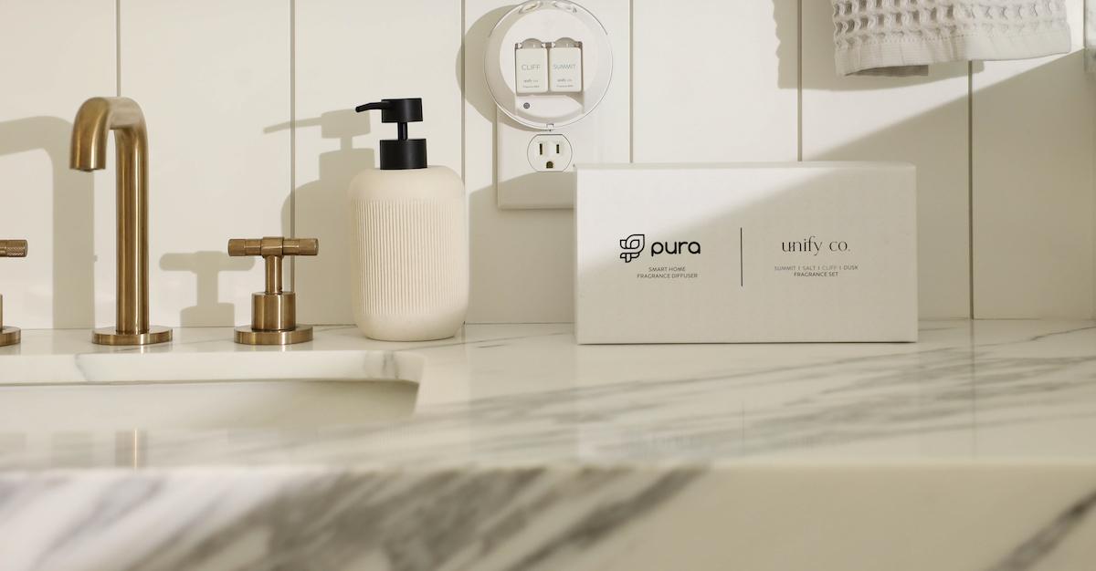 An all-white bathroom with a Pura plug-in.