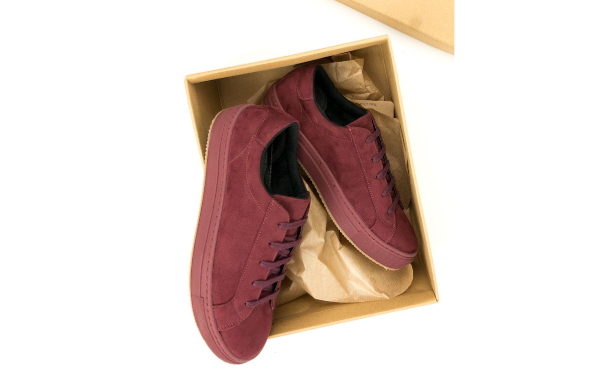 Red sneakers in a cardboard box from Will's Vegan Store. 