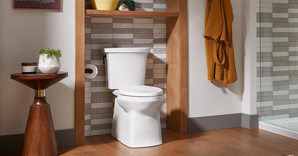 Photo of a white Kohler toilet in a bathroom with wood detailing