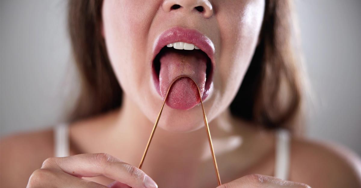 woman using a copper tongue scraper