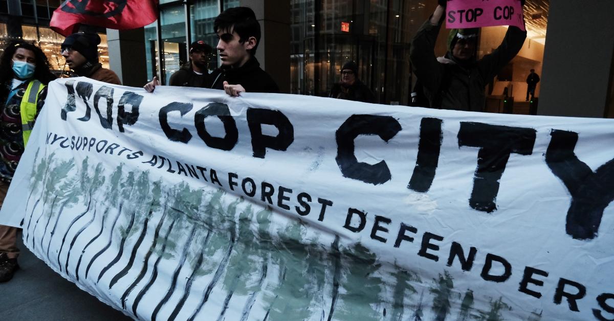 Activists hold a banner reading "Stop Cop City: NYU supports Atlanta Forest Defenders"