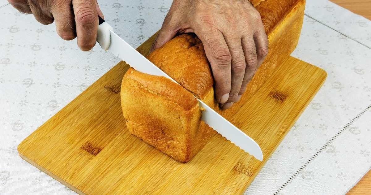 Individual slicing off the end portion from a loaf of bread. (Representative Cover Image Source: Getty Images | Antanas Tusla)