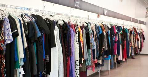 Thrift store clothing rack along wall