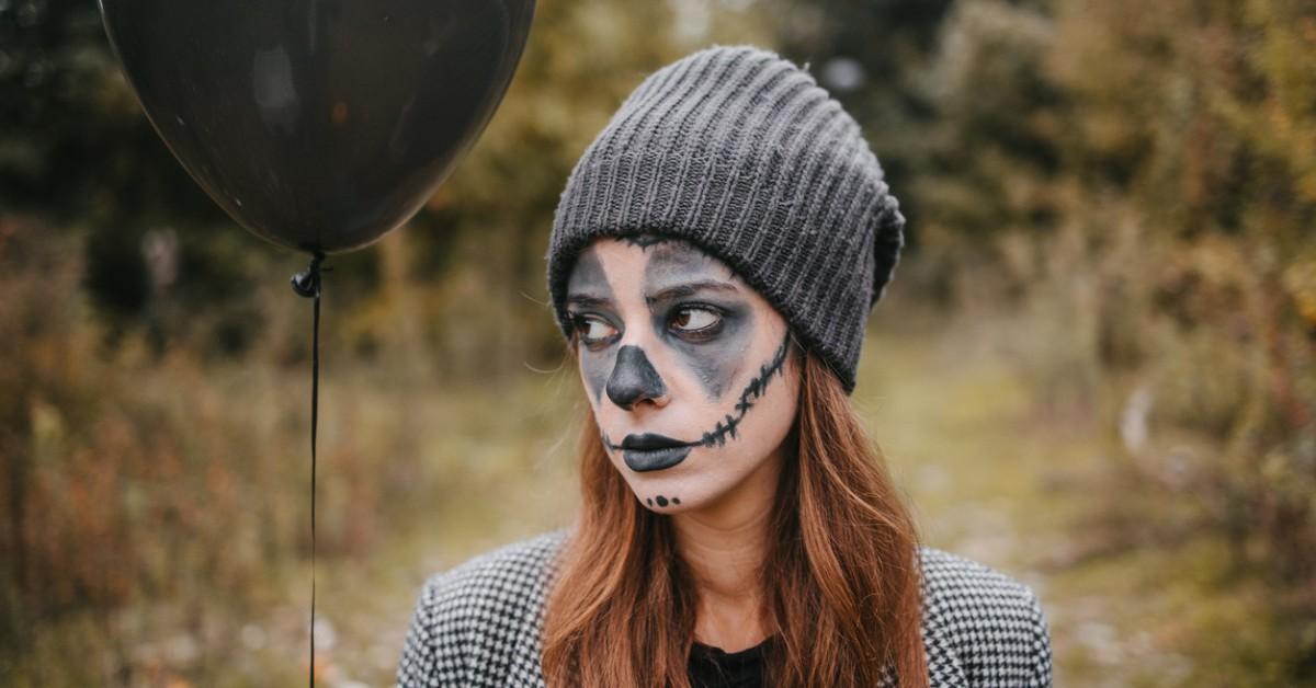 Woman uses black face paint to create a sad looking clown costume