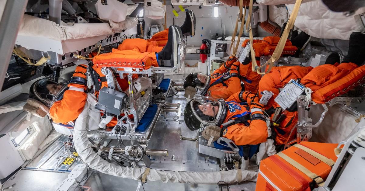 Astronauts wear space suits while strapped into Artemis II