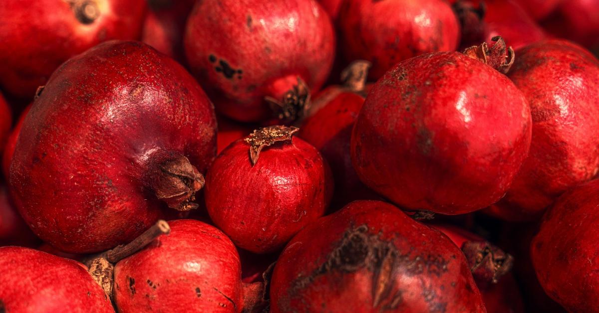 A pile of dirty red pomegranates. 