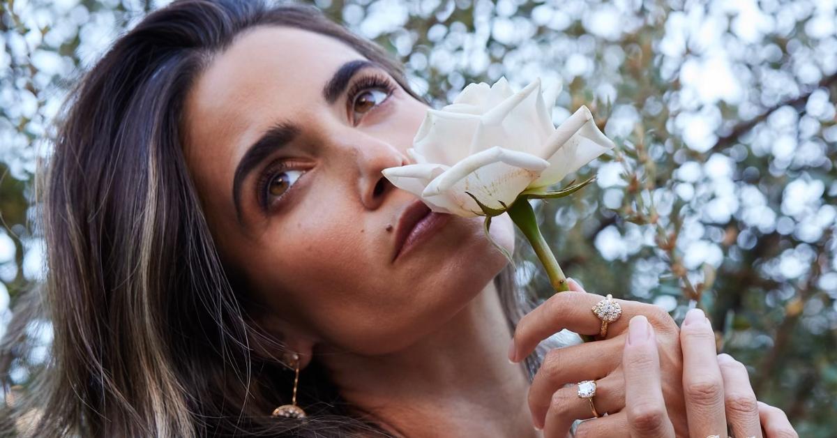 Photo of actor and eco-conscious entrepreneur Nikki Reed holding a white flower to her nose