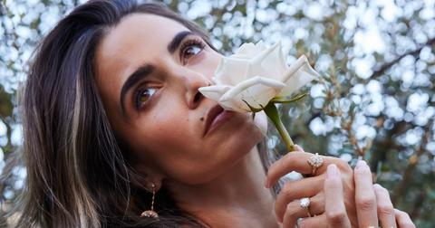 Photo of actor and eco-conscious entrepreneur Nikki Reed holding a white flower to her nose
