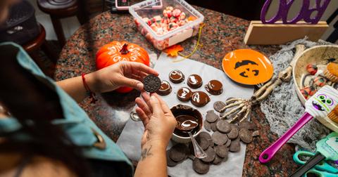 Person making homemade halloween-themed treats.
