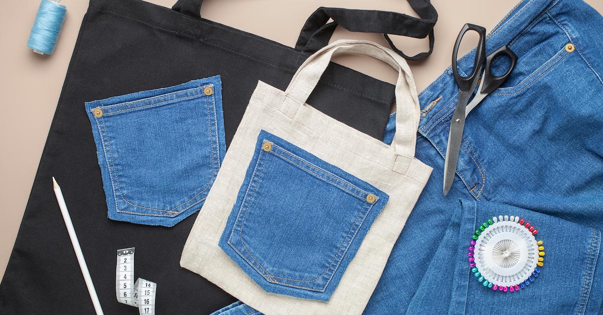 Denim being used to sew a tote bag, along with sewing and craft supplies.