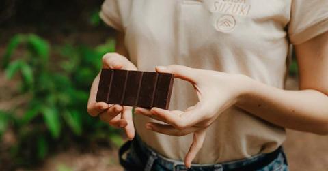 Woman holding a bar of dark chocolate (Representative Cover Image Source: Unsplash | Kawe Rodriguez)