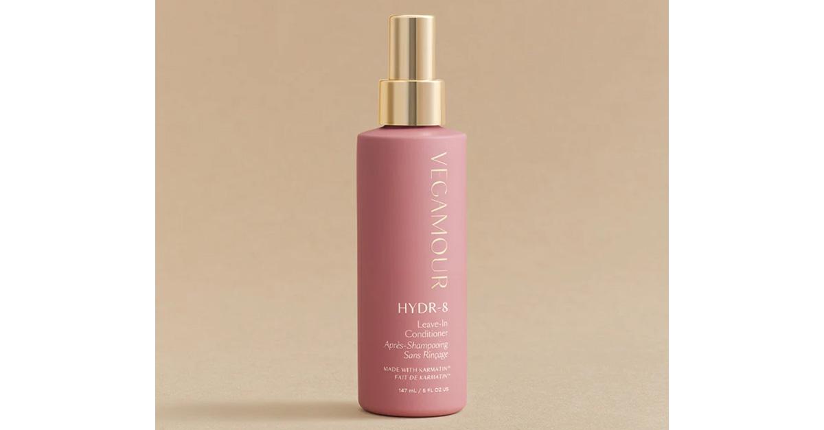 heat protectant spray in pink bottle on tan background