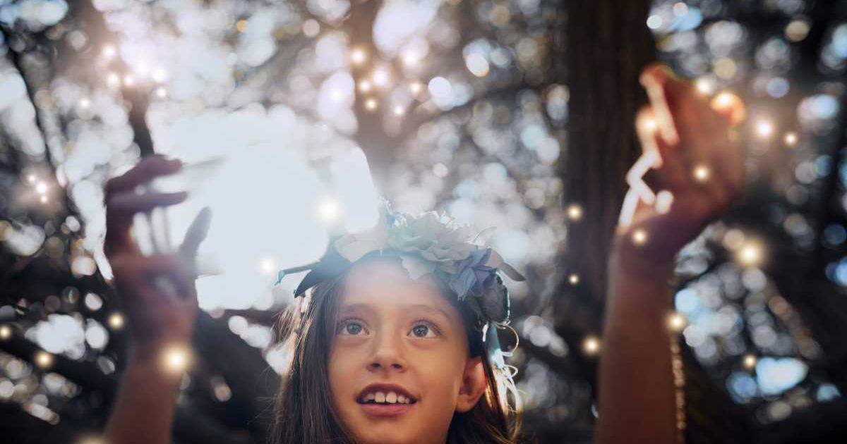 Girl enjoying the surreal light show of fireflies in a garden forest (Representative Cover Image Source: Getty Images | People Images)