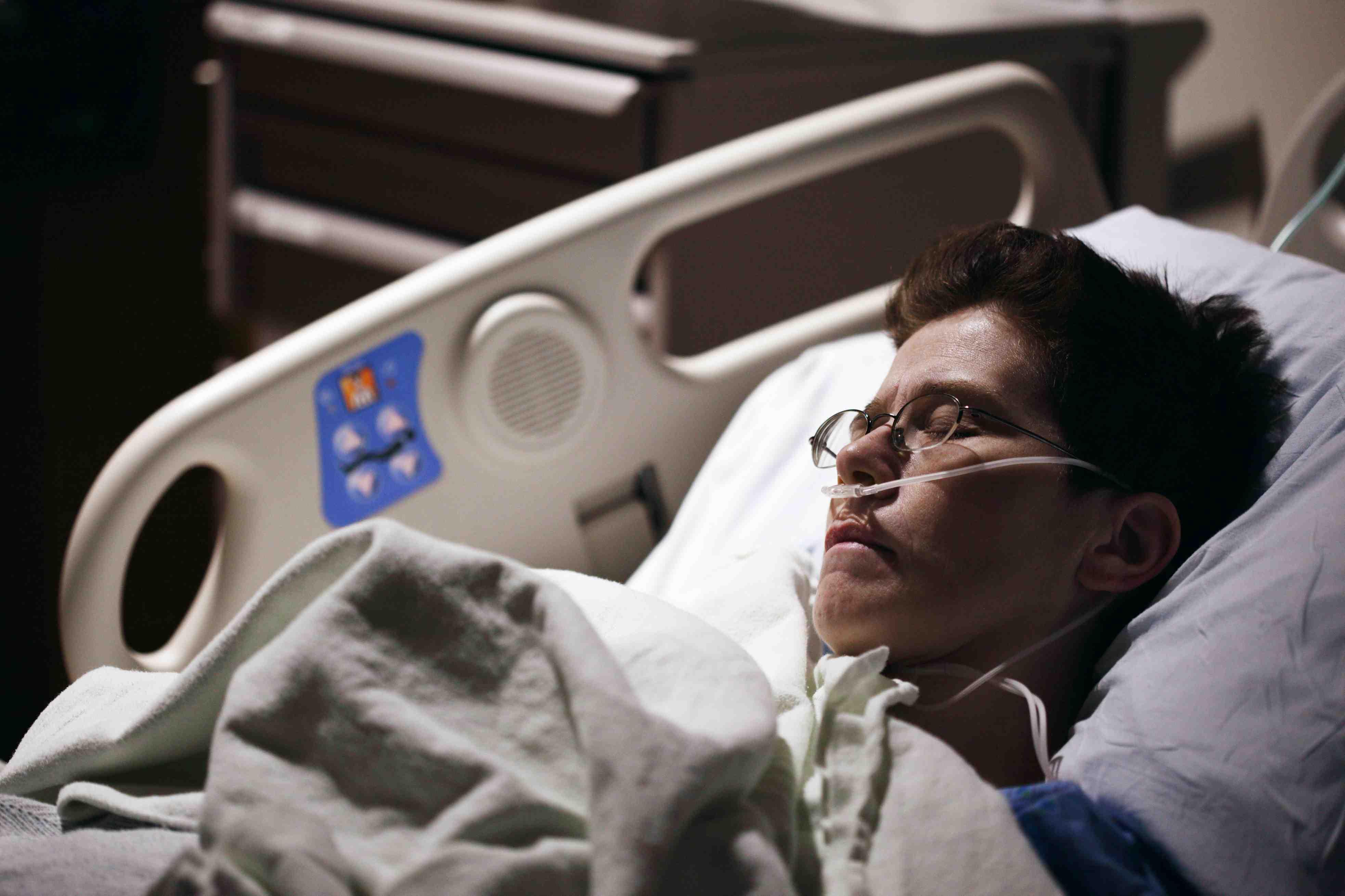 A hospital patient lays in bed.