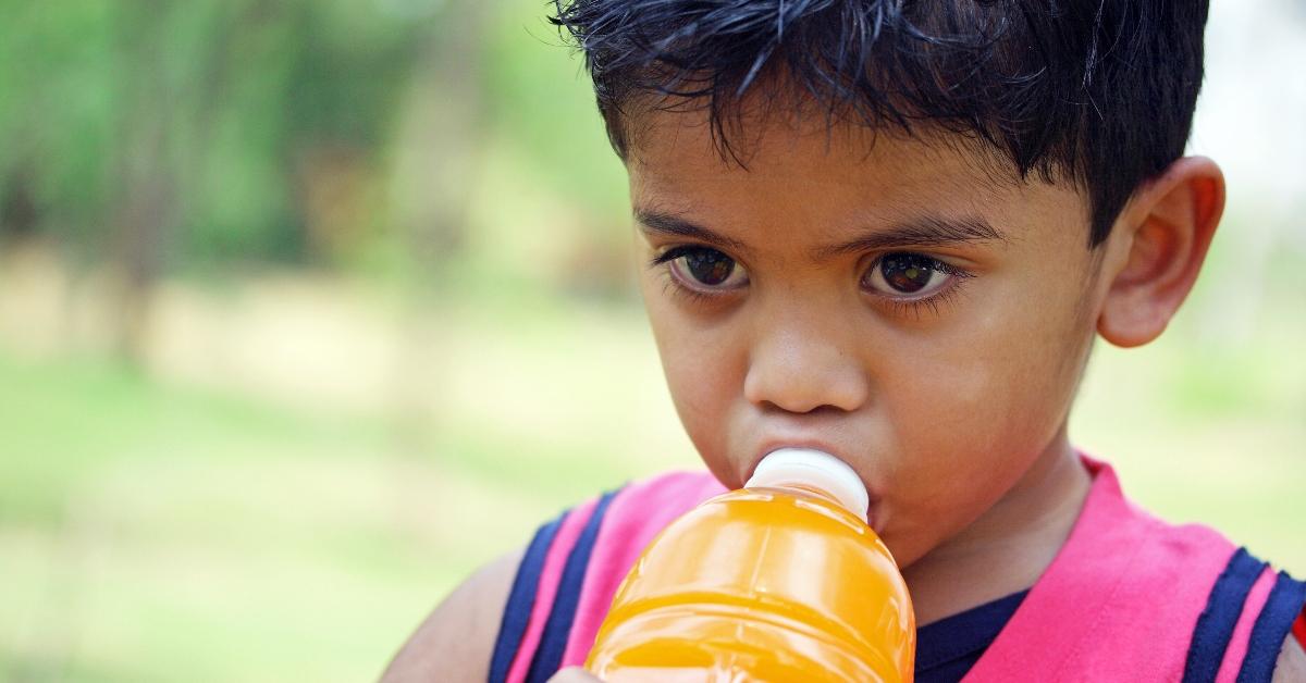 A boy drinking a sports drink.