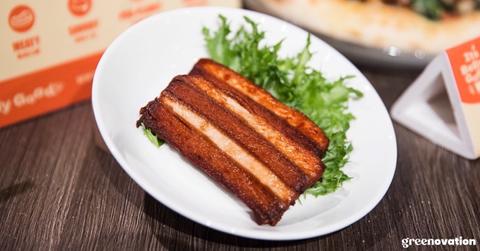 A slice of Lypid's vegan pork belly and greens on a dish